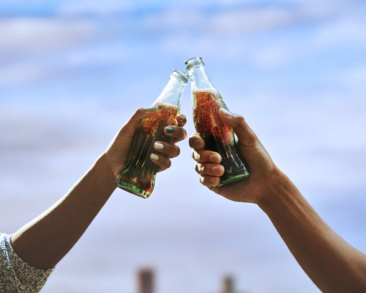 Coca-Cola bottles in hands