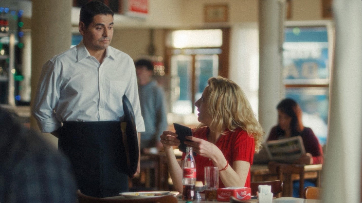Un mozo atendiendo a una señora en un bar en el marco de una nueva edición de su campaña nacional.
