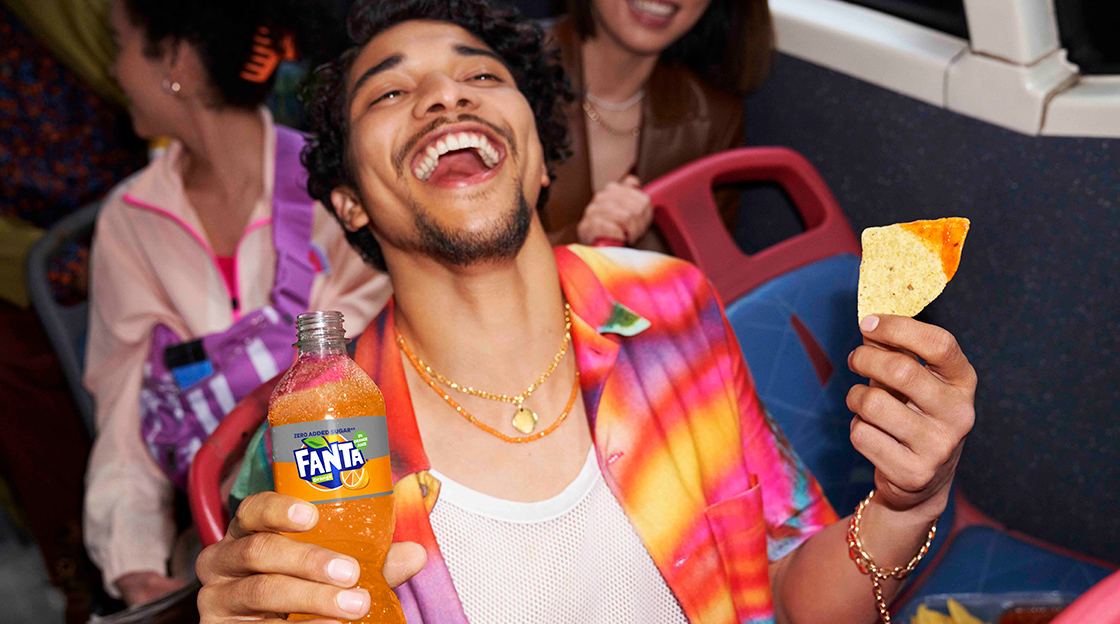 Man drinking fanta and eating nachos