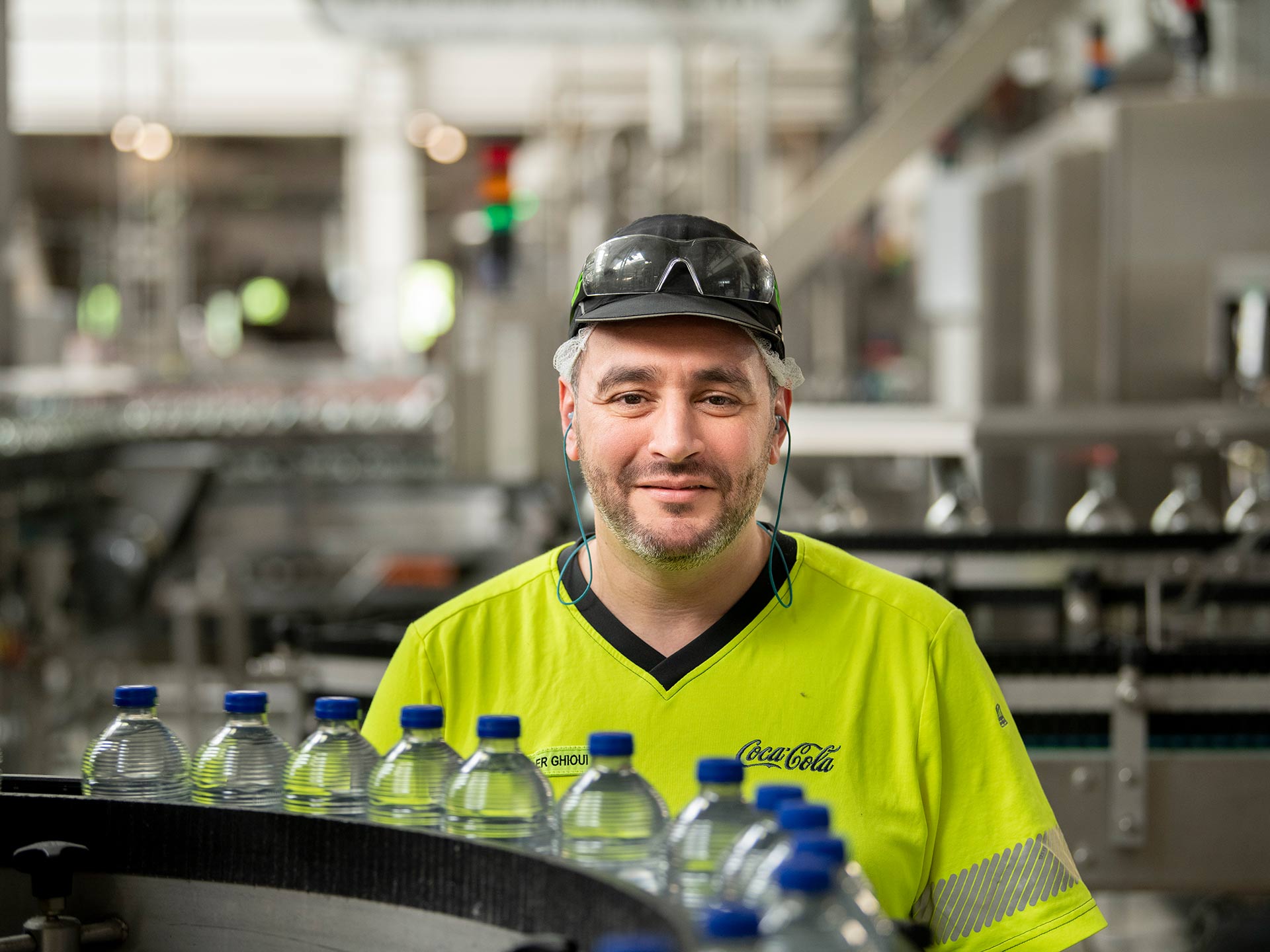 Man aan lopende band in productie eenheid Coca-Cola