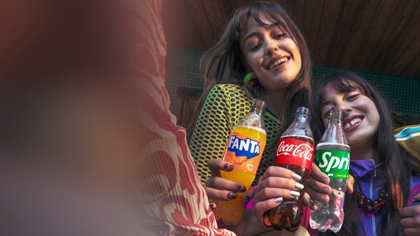 Три момичета държат бутилки: Fanta, Coca-Cola and Sprite