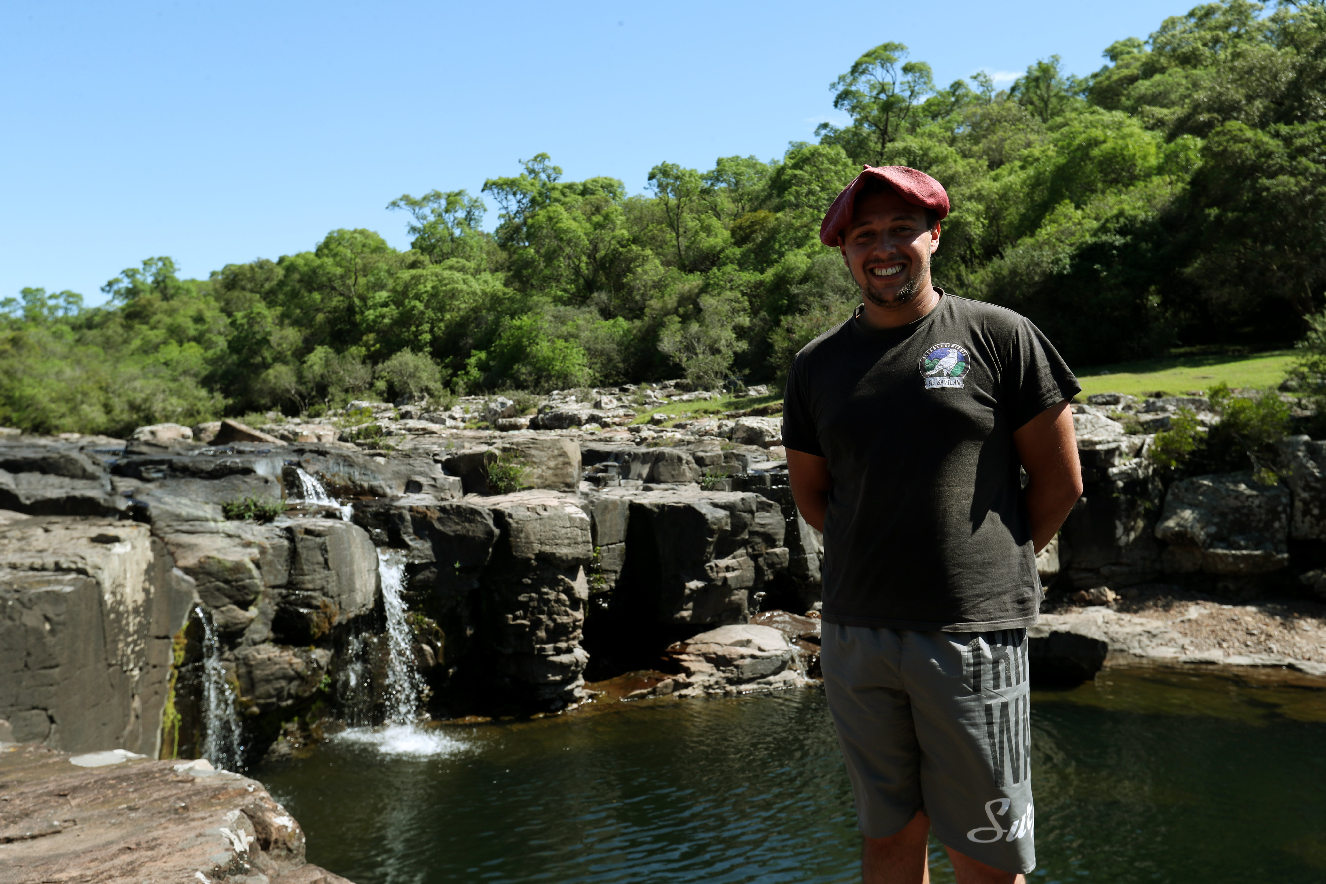 Jóven posa con una cascada de fondo