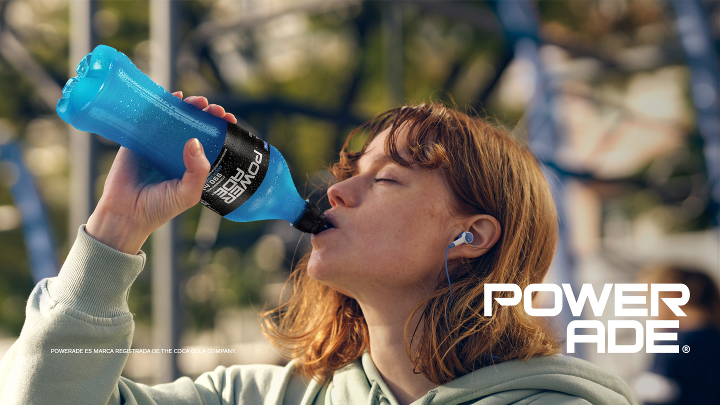 Una jóven toma de una botella de Powerade