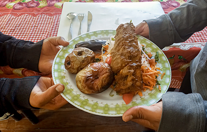 Dos personas sostienen un plato de comida