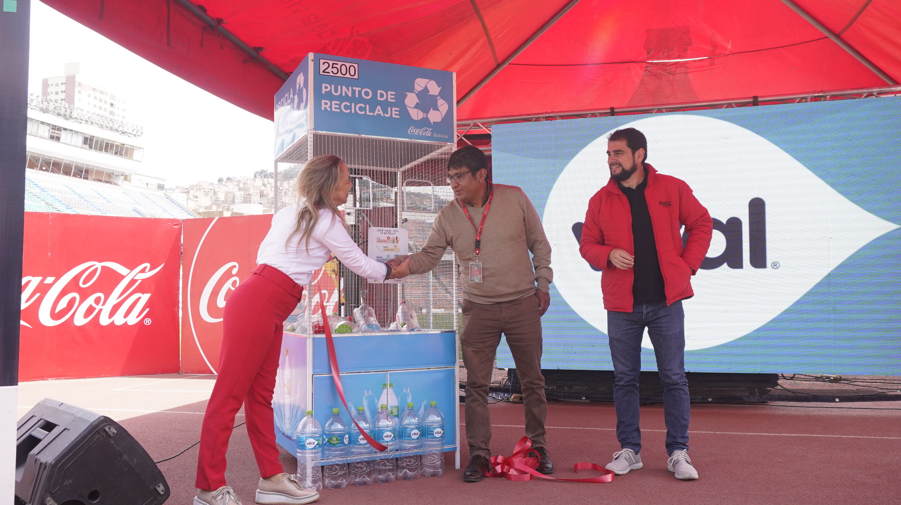 Un hombre y una mujer estrechan sus manos, en la entrega de los contenedores