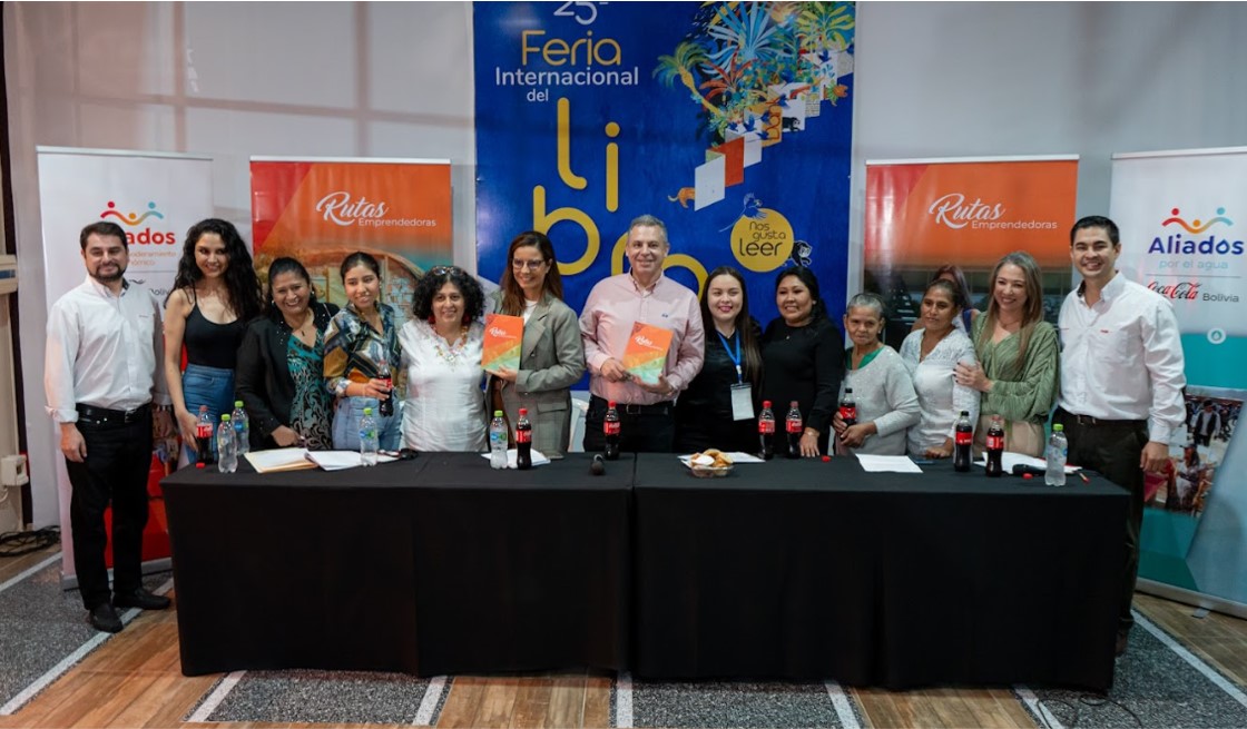 personas posando para la foto atrás de una mesa para la feria de libro