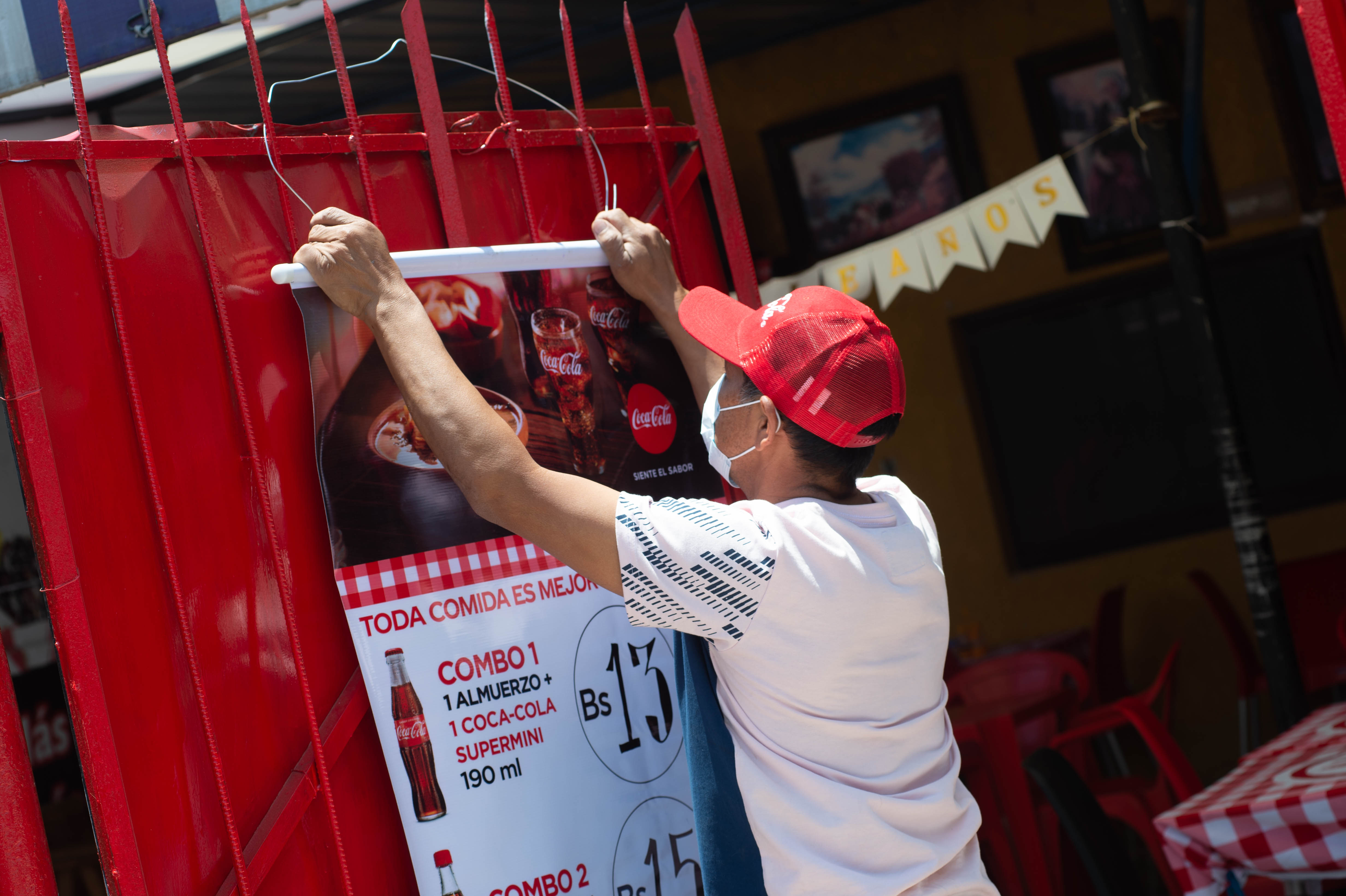 Hombre coloca un cartel en la puerta de un negocio