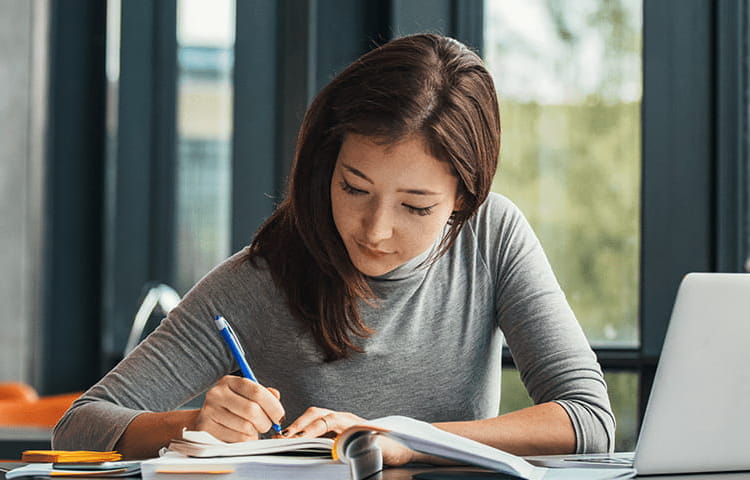 A young woman is studying at a desk in College