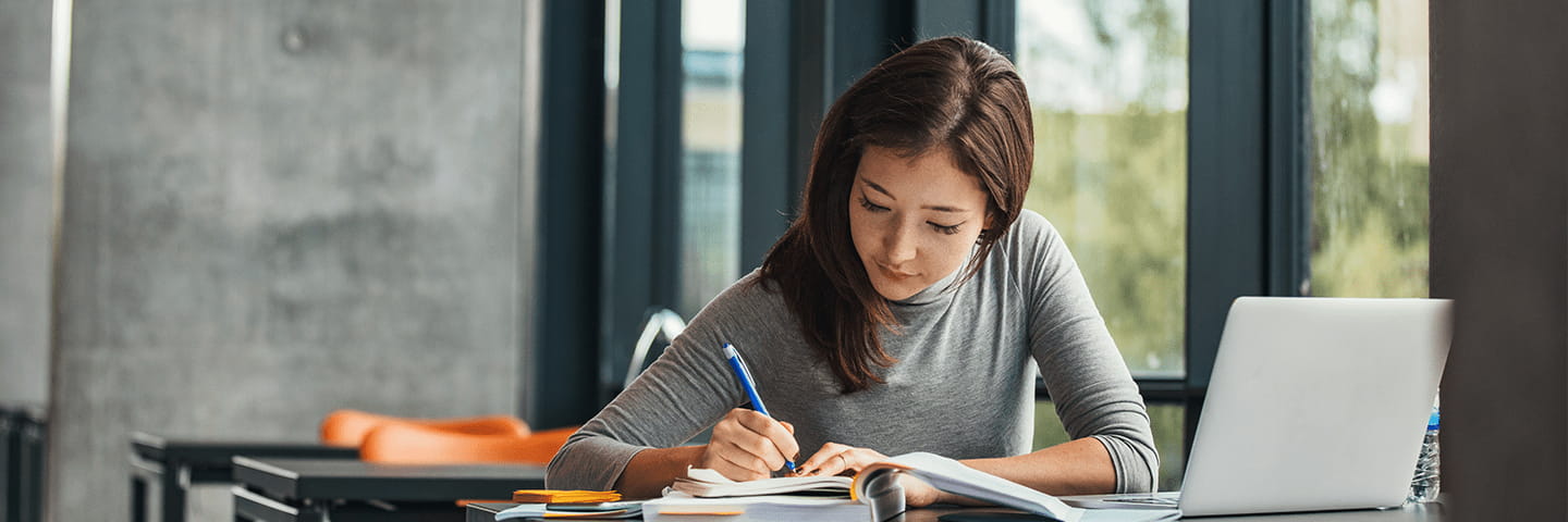 A young woman is studying at a desk in College