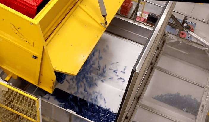 A machine pouring small plastic tubes 