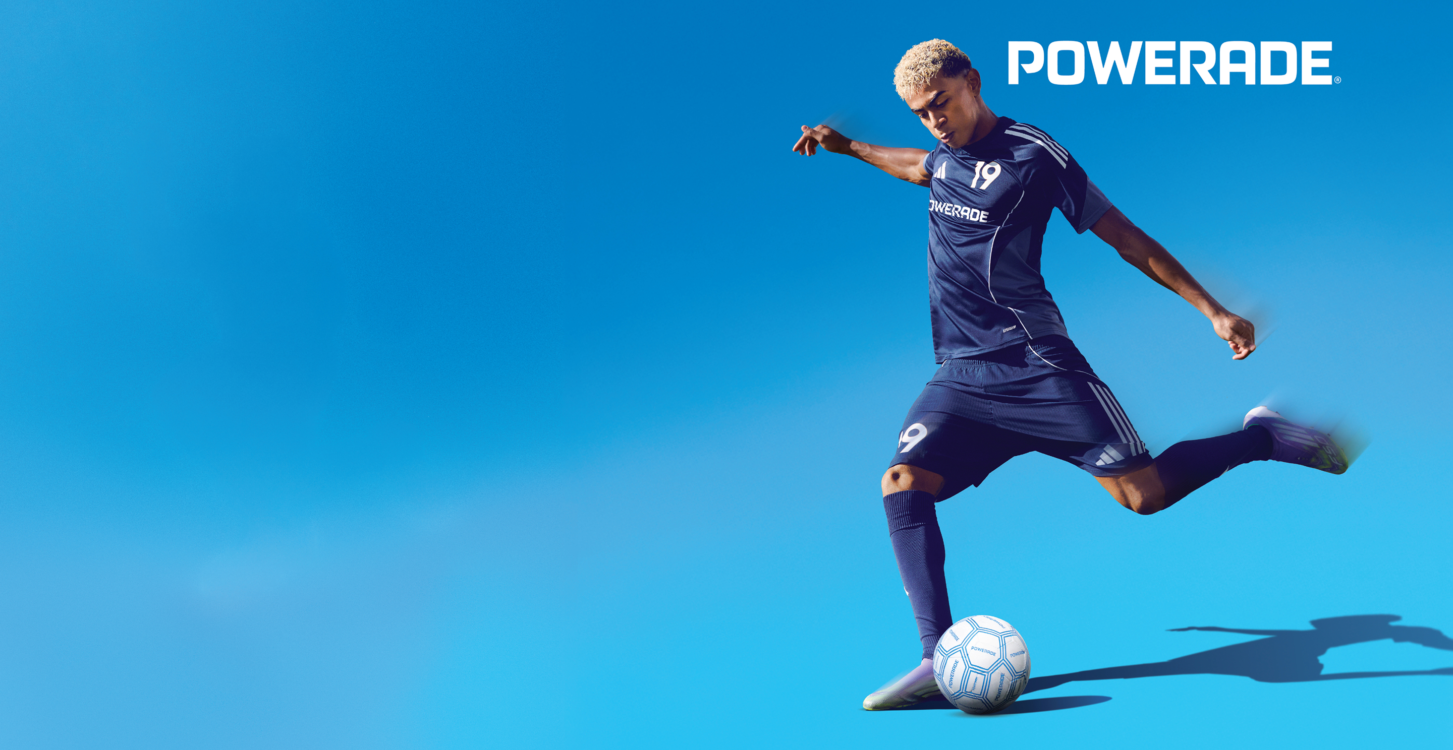 A soccer player kicking a ball on a blue background