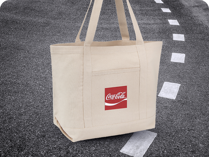 A beige canvas tote bag with a red Coca-Cola logo patch, a practical prize from the Road Trip contest prize pool.