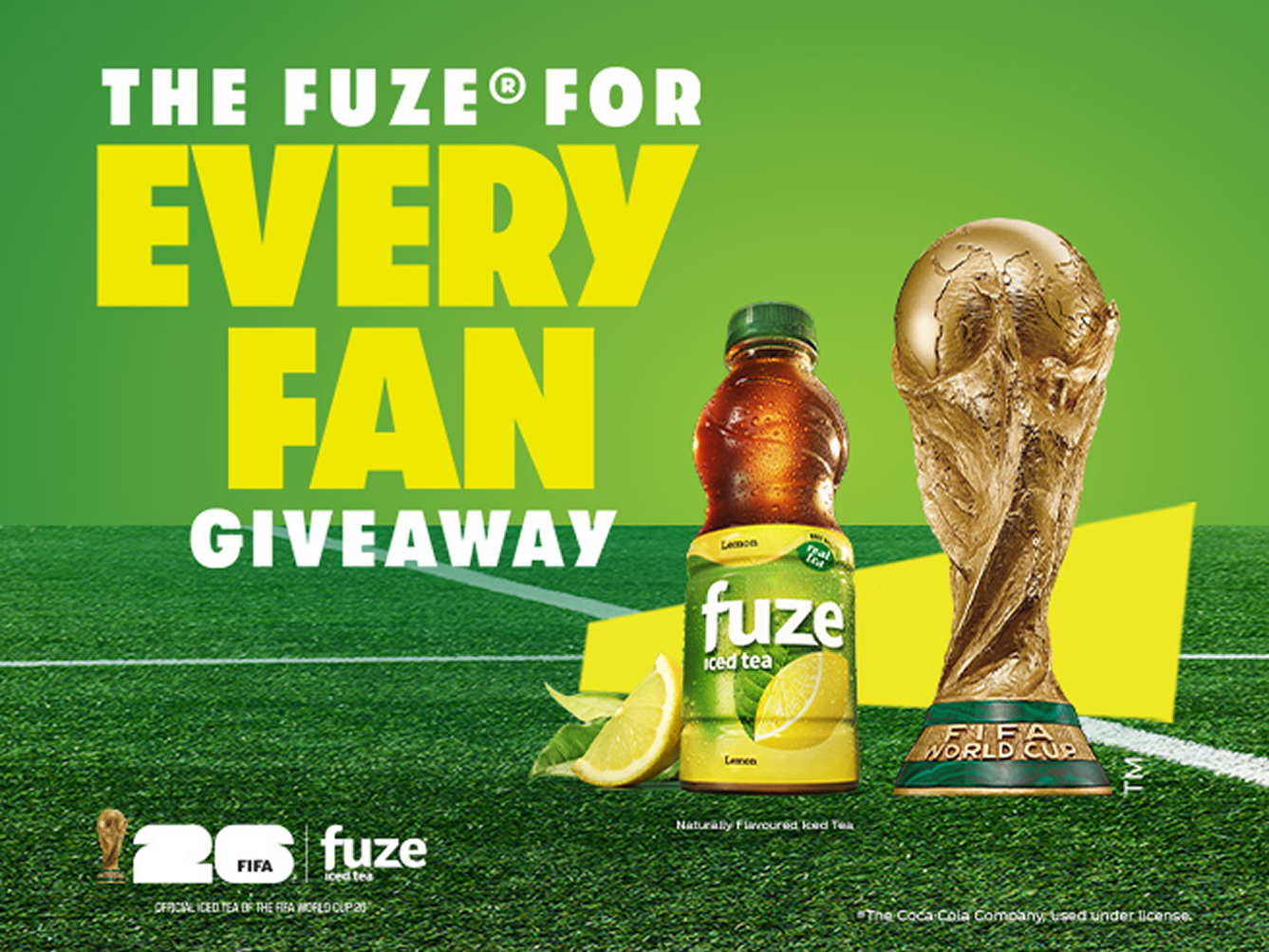 FUZE® iced tea lemon bottle beside FIFA World Cup Trophy on green soccer pitch promoting The FUZE For Every Fan giveaway