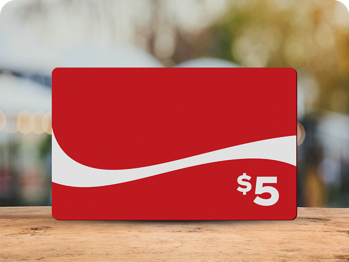 Une carte-cadeau prépayée rouge de 5 $ de marque Coca-Cola avec le ruban dynamique, un prix du concours L'été à gratter.