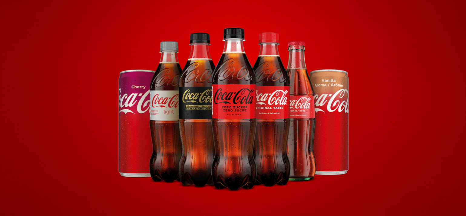 Alignement de différentes variétés de Coca-Cola disponibles en Suisse sur fond rouge.