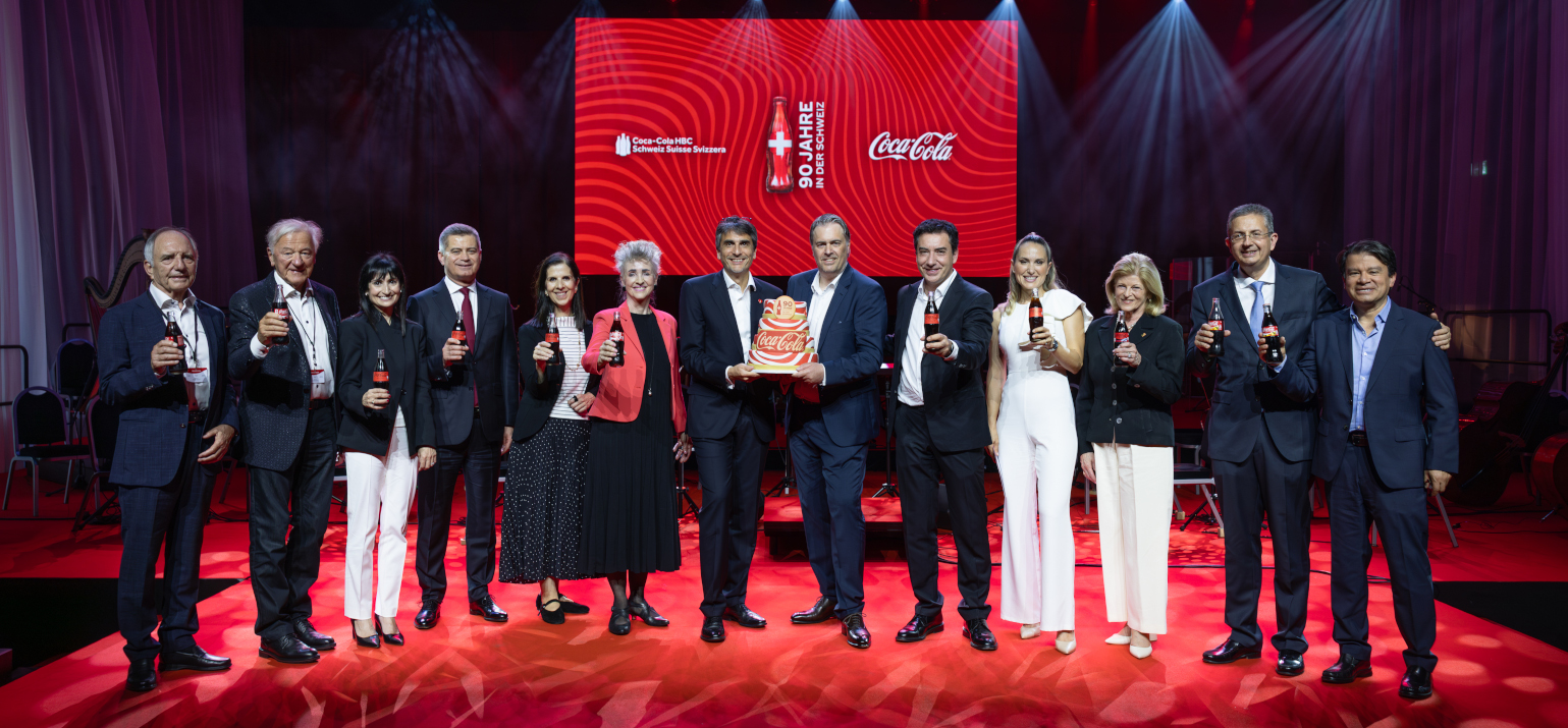 Gäste und Vertreter:innen des Coca-Cola Systems stossen beim Jubiläum von Coca-Cola Schweiz im Schiffbau Zürich an.
