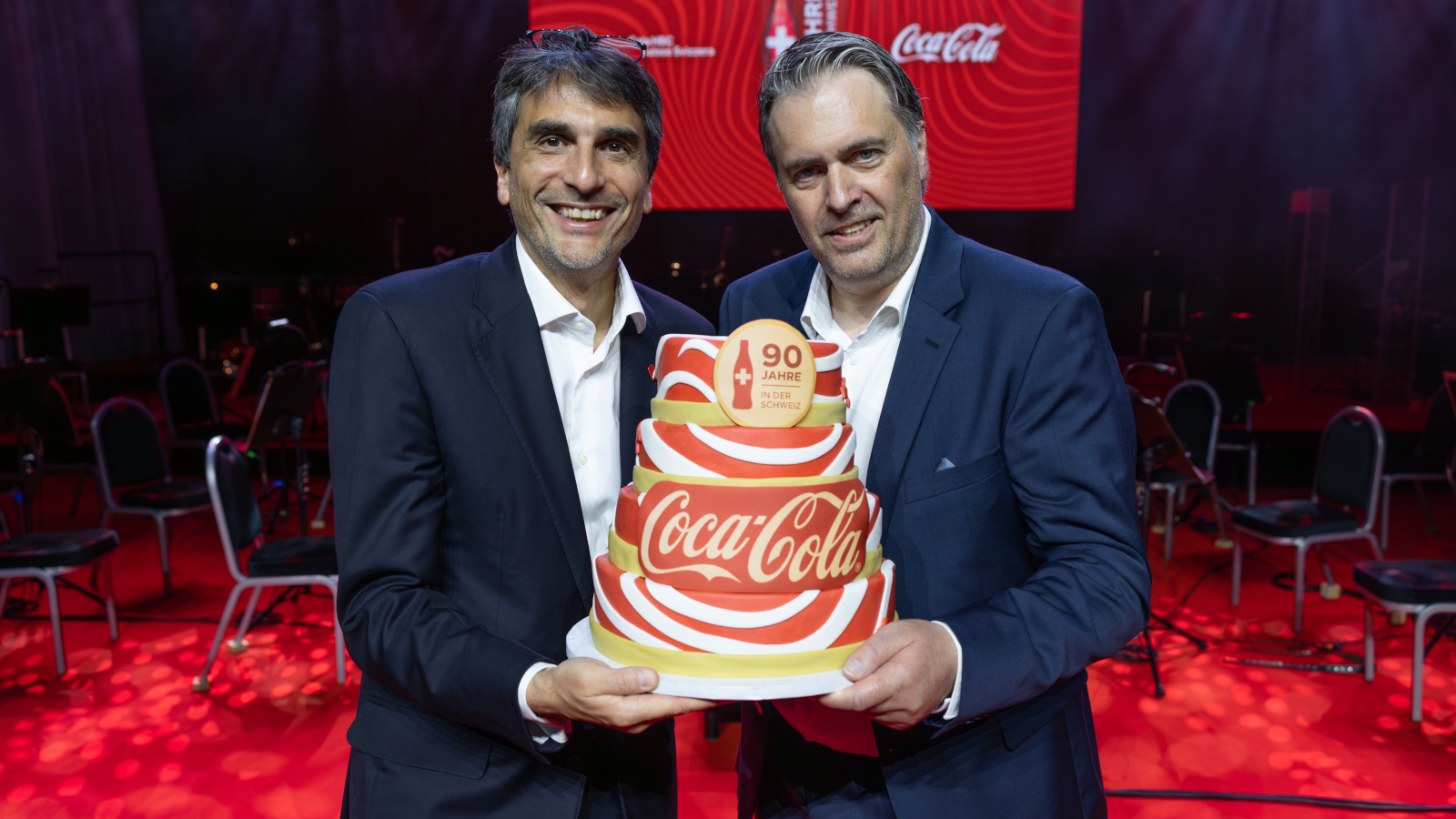 Fabio Cella und Jürg Burkhalter präsentieren den Coca-Cola Geburtstagskuchen.
