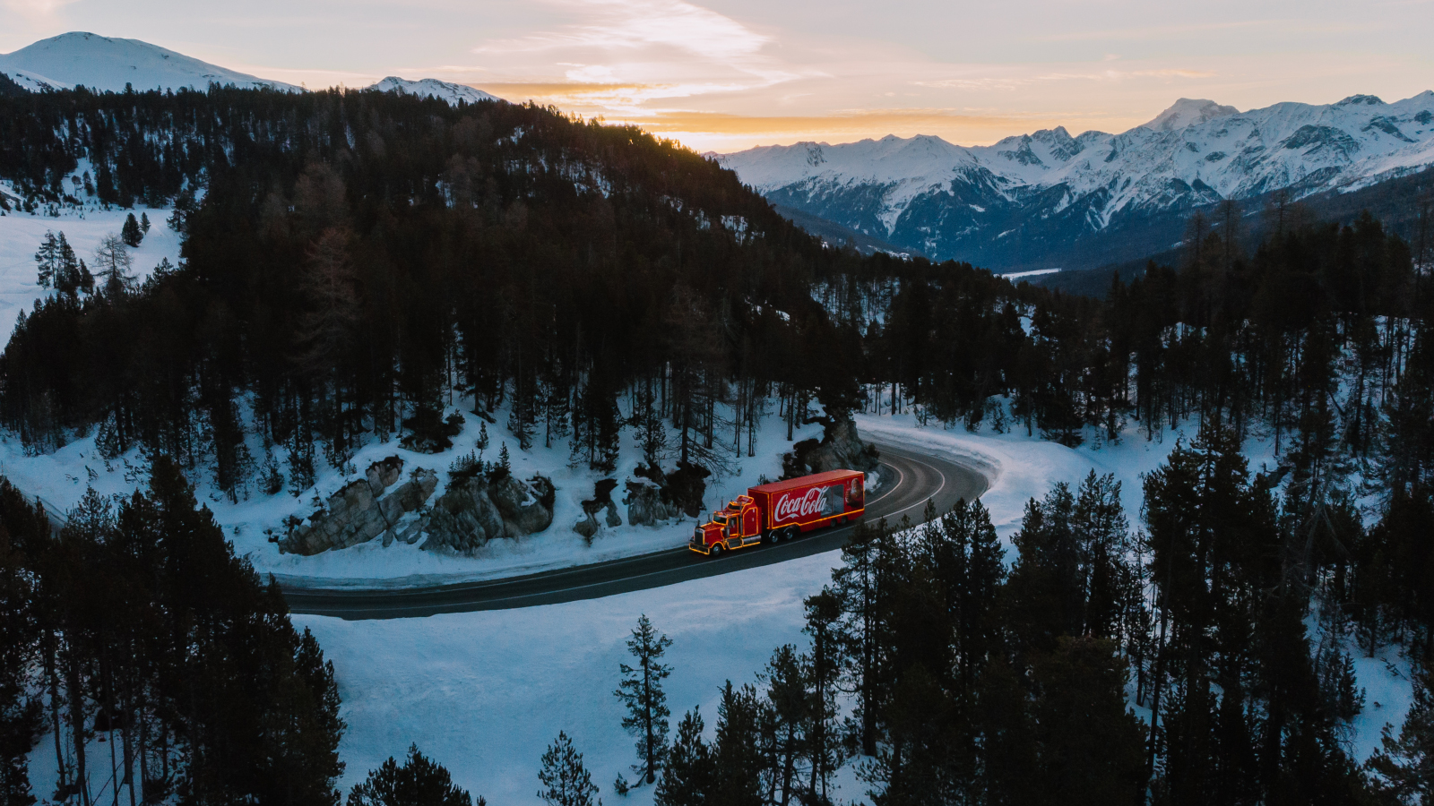 truck on a street between mountains at sunset