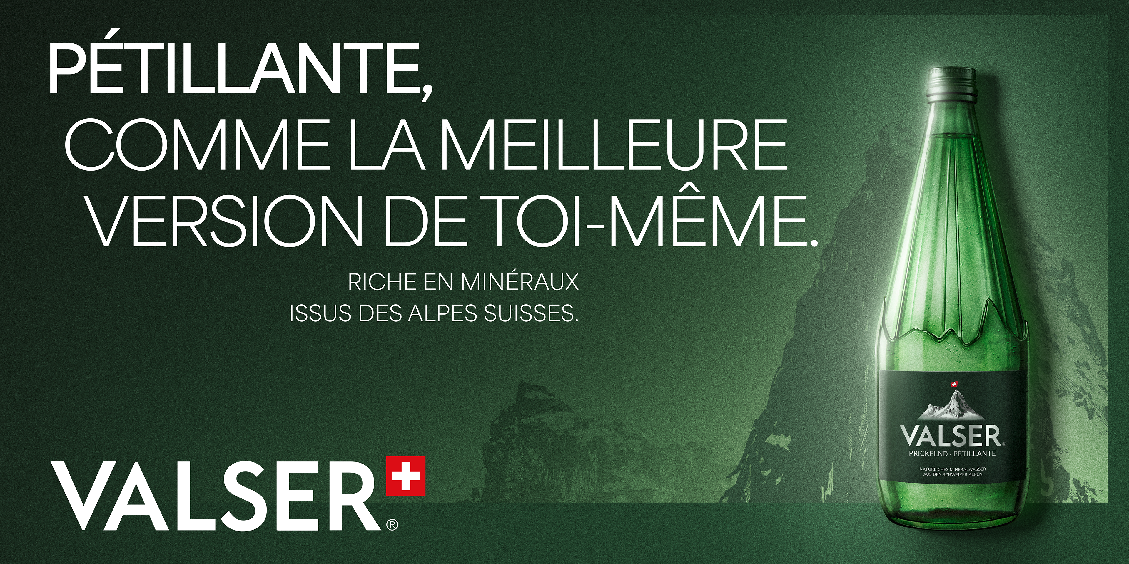 Bouteille Valser sur une table avec verre d’eau et assiette