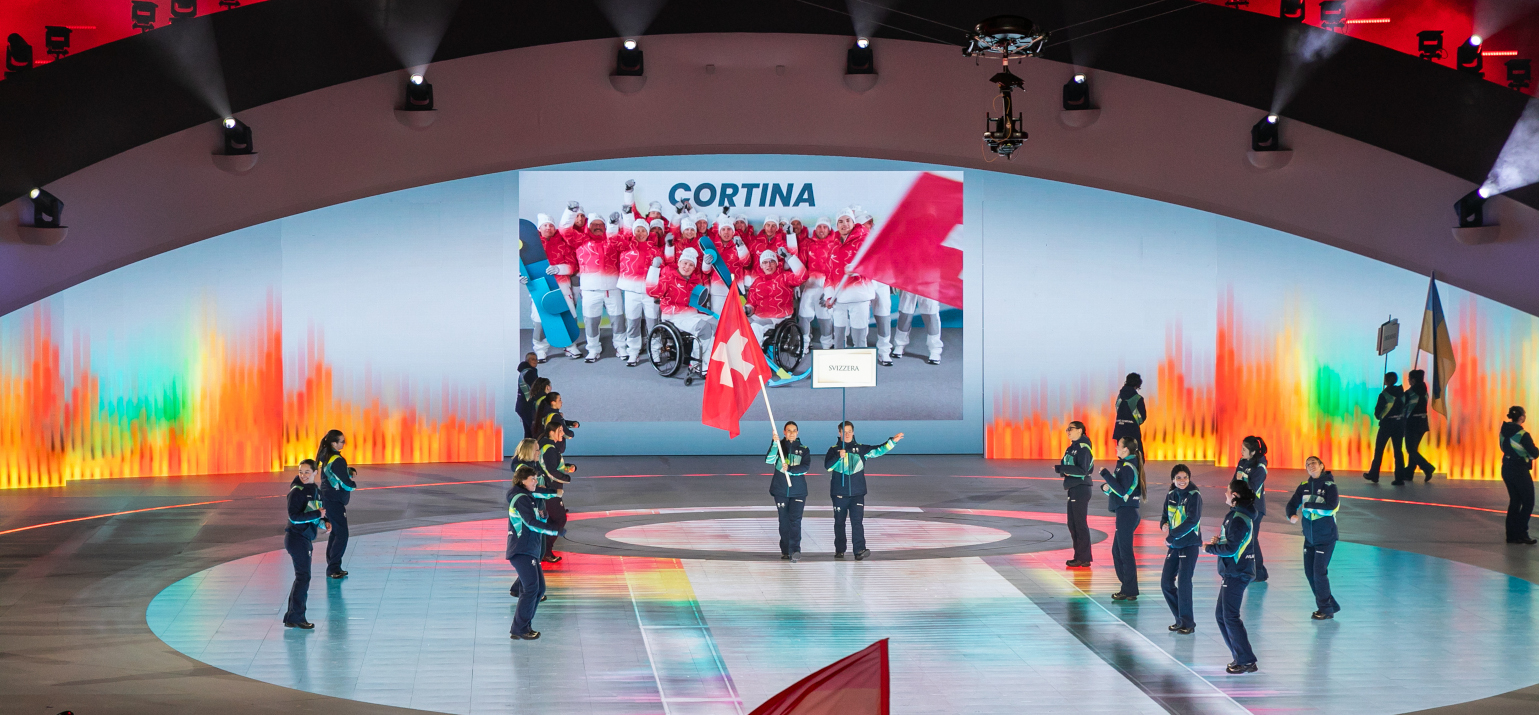 Flavio avec la porteuse du drapeau sur scène lors de la cérémonie d'ouverture des Jeux paralympiques d'hiver à Vérone.