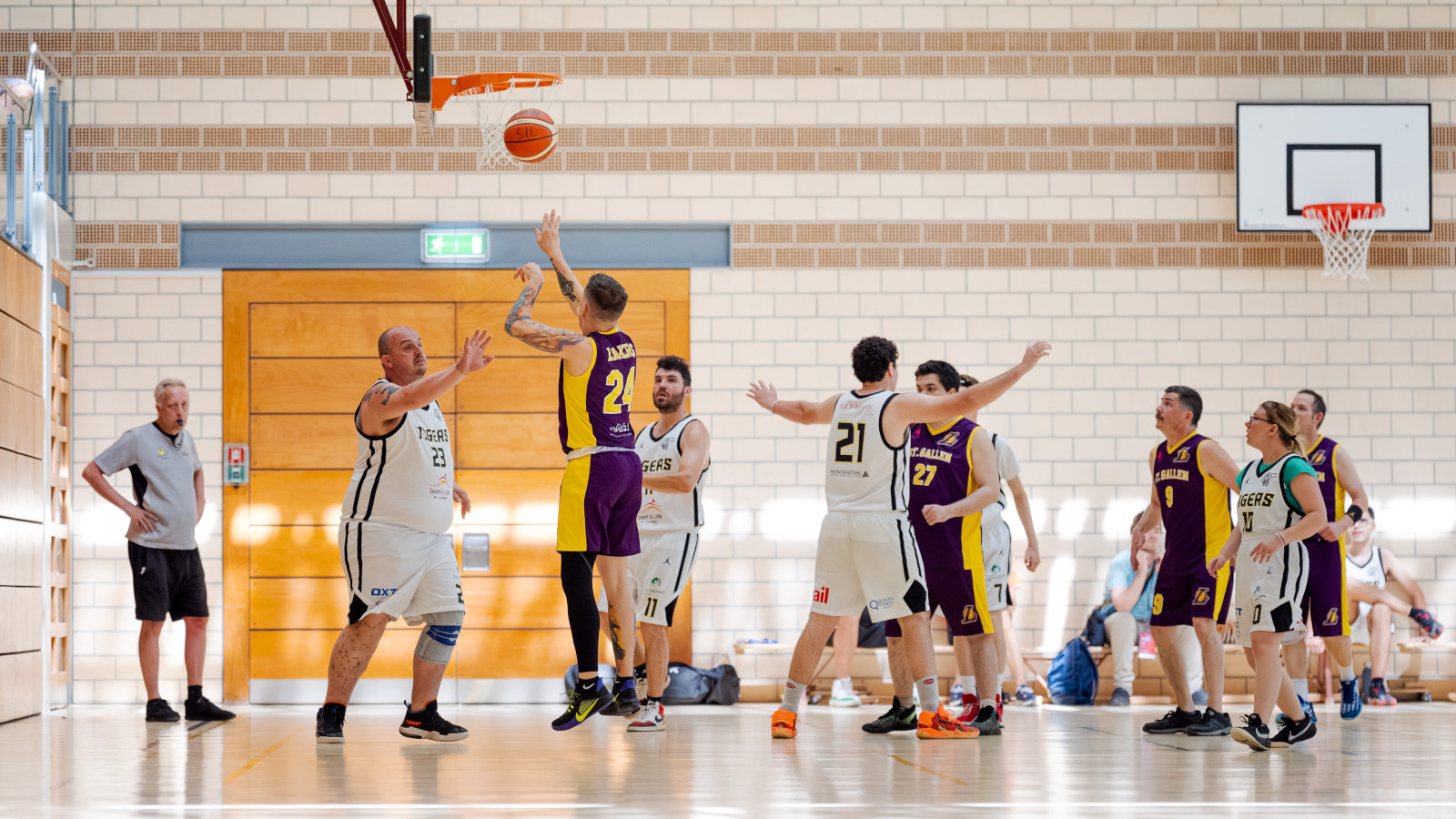 Athleten spielen Basketball in der Halle.