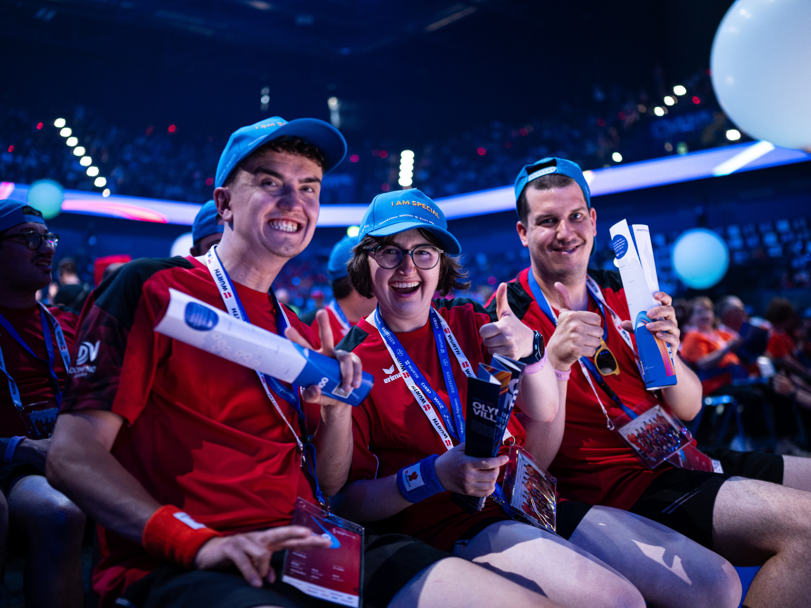 Drei Teilnehmende sitzen bei der Eröffnungsfeier der Special Olympics National Games im Publikum.