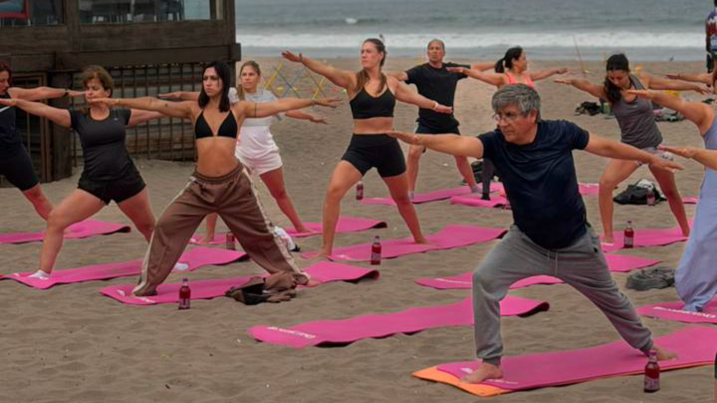 Grupos de personas realizando yoga en una playa de Viña del Mar.