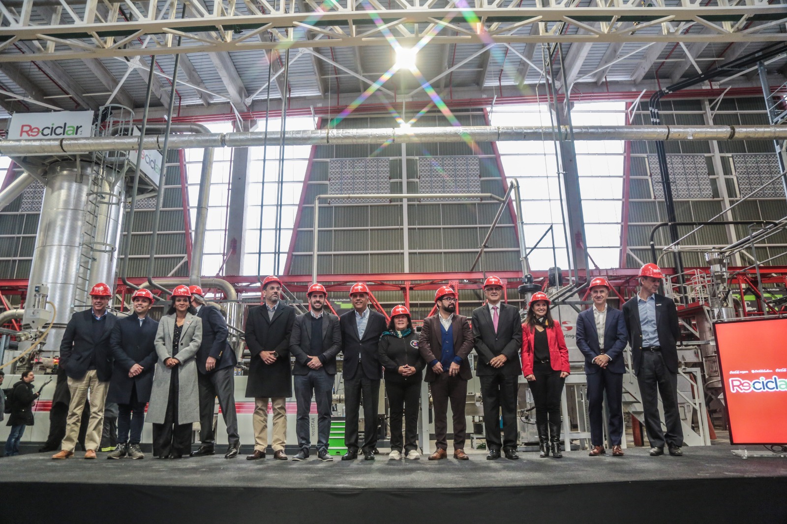 Imagen de la fábrica Re-Ciclar con personas de Coca-Cola arriba de un escenario