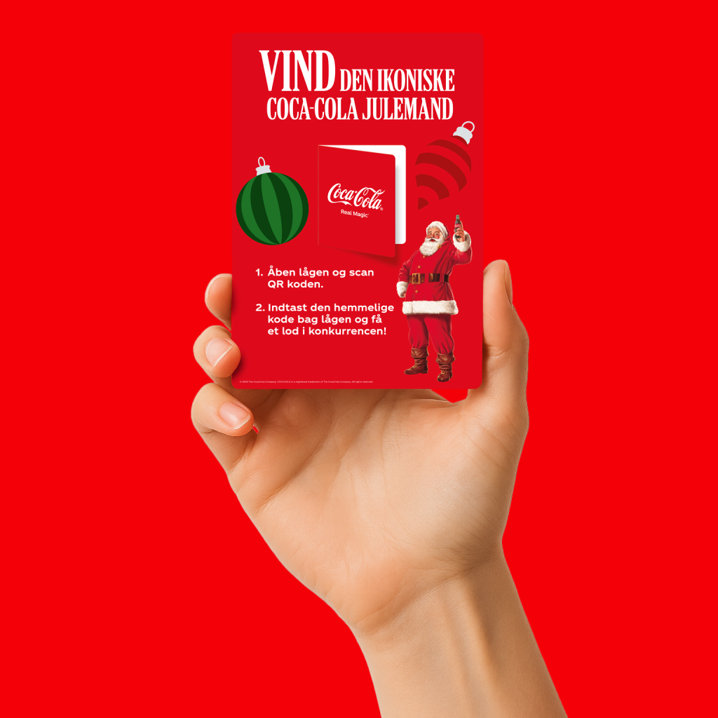 Hånd, der holder et skrabelod til at vinde en Coca-Cola julemand