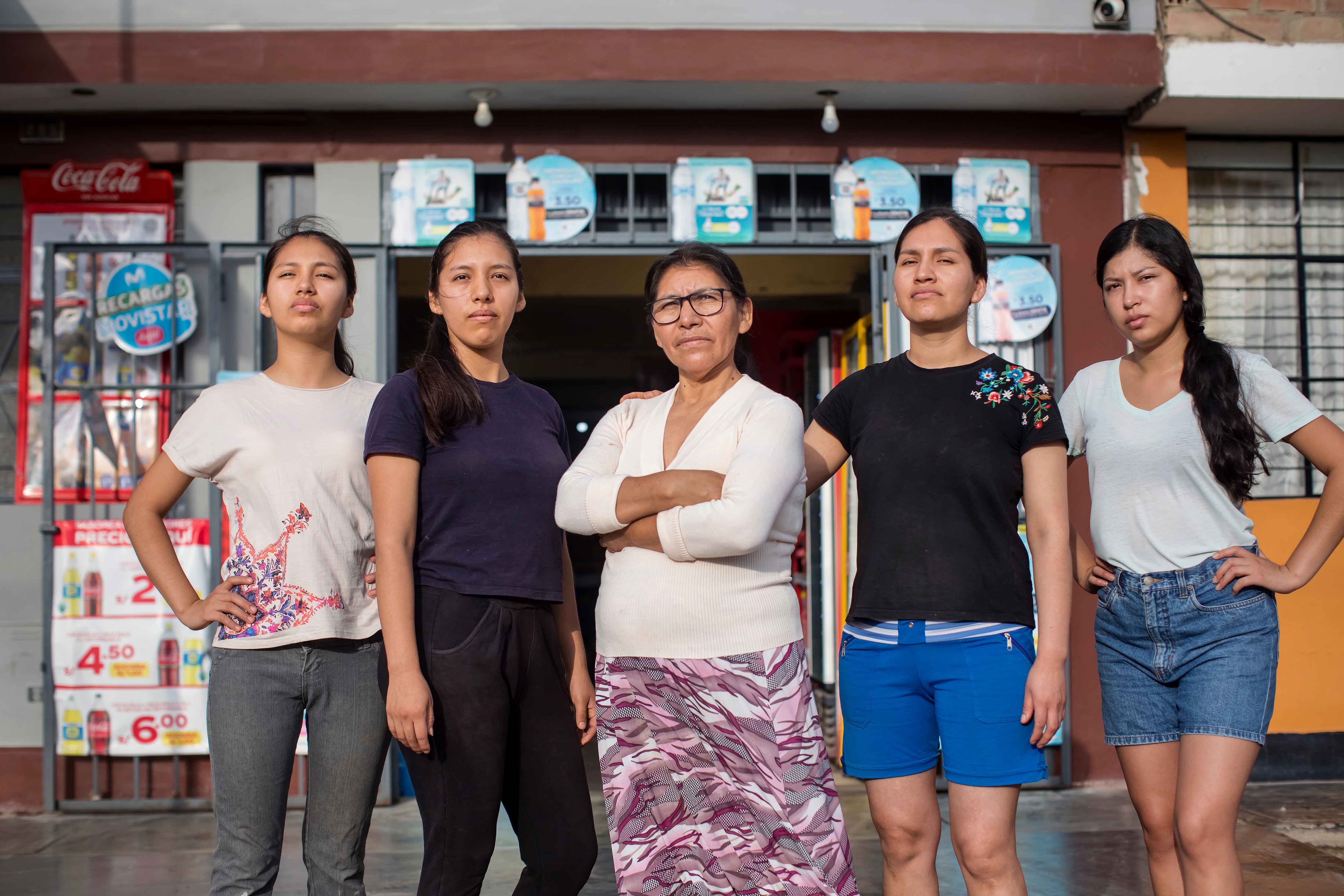 Mujeres posan frente a un comercio