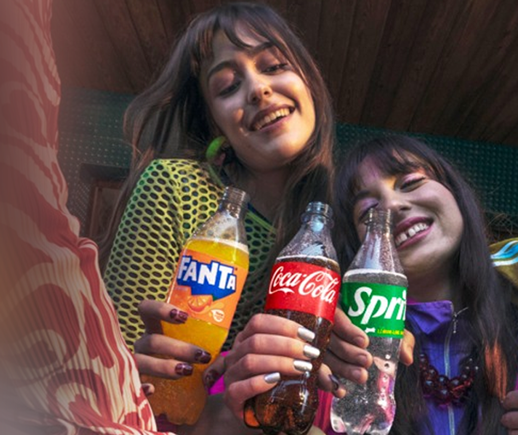Kaks sõpra hoiavad Coca-Cola, Fanta ja Sprite’i pudeleid.