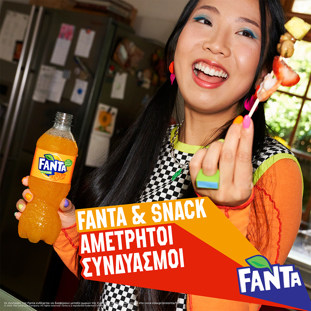 Woman with bottle of Fanta and fruit on cocktail stick