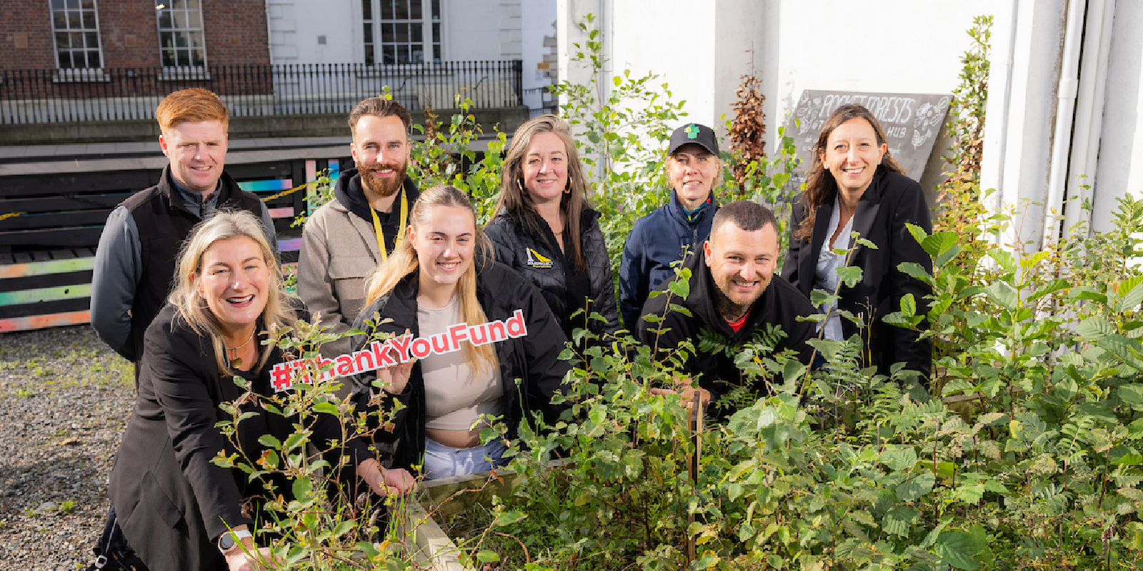 The 2023 Thank You Fund winners standing in front of a flower bed