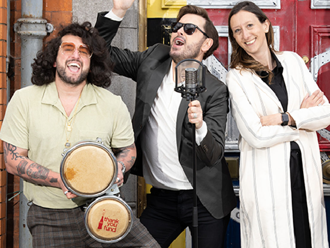 Band playing music and posing for a photograph in front of a building