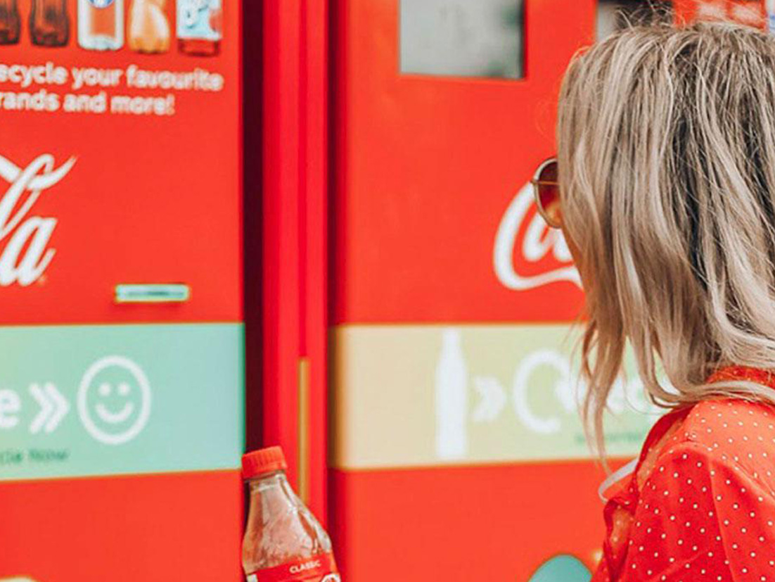 Multiple empty glass bottles of Coca-Cola in the foreground with an out-of-focus background