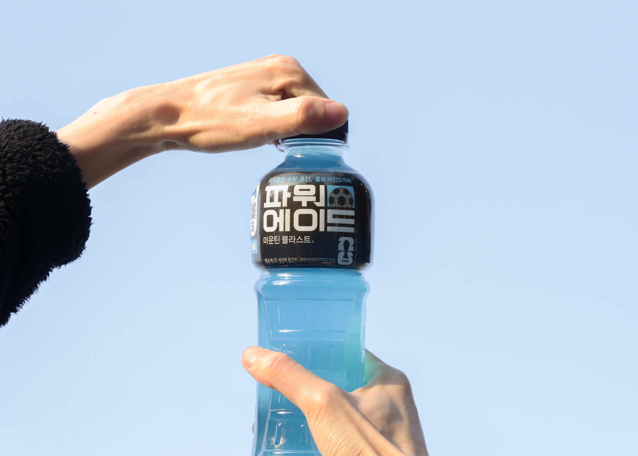 파워에이드 26 FIFA 월드컵 스페셜 패키지를 마시기 위해 제품 뚜껑을 열고 있는 이미지