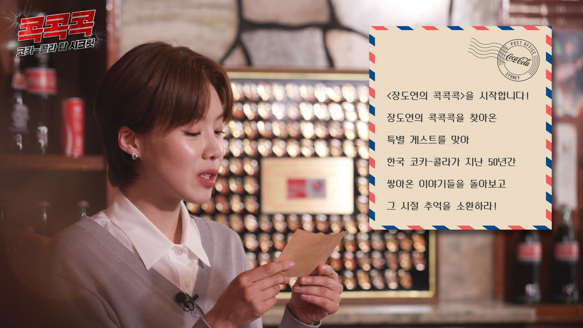 콕콕콕 12화 유튜브 영상 캡쳐본이다. 장도연이 미션지를 읽고 있고 미션지에는 ‘<장도연의 콕콕콕>을 시작합니다! 장도연의 콕콕콕을 찾아온 특별 게스트를 맞아 한국 코카-콜라가 지난 50년간 쌓아온 이야기들을 돌아보고 그 시절 추억을 소환하라!라고 적혀있다.