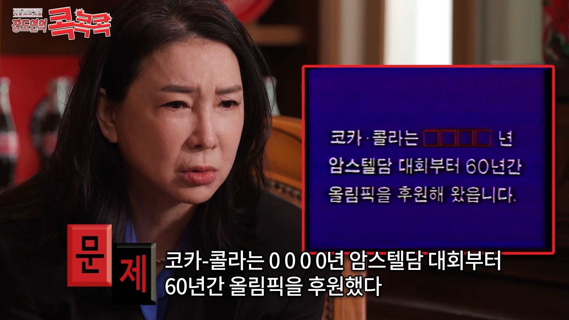 콕콕콕 12화 유튜브 영상 캡쳐본이다. 심혜진이 문제화면을 응시하고 있고 하단에는 코카-콜라는 0000년 암스텔담 대회부터 60년간 올림픽을 후원했다라는 자막이 적혀있다.