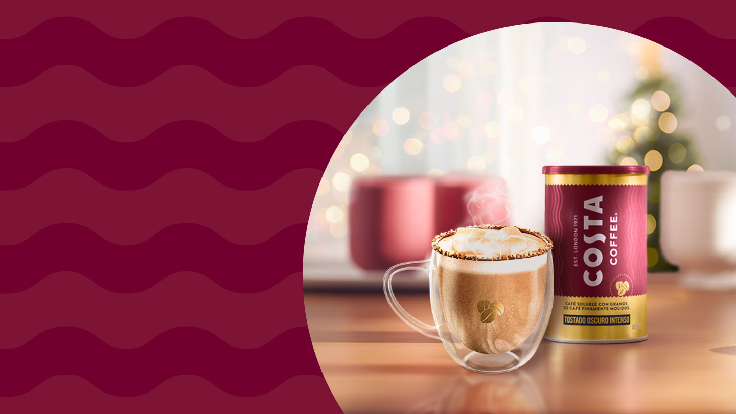 Fotografía de un envase de Costa Coffee Molído y una taza de café. En el fondo y fuera de fodo, un árbol de navidad y decoración navideña.