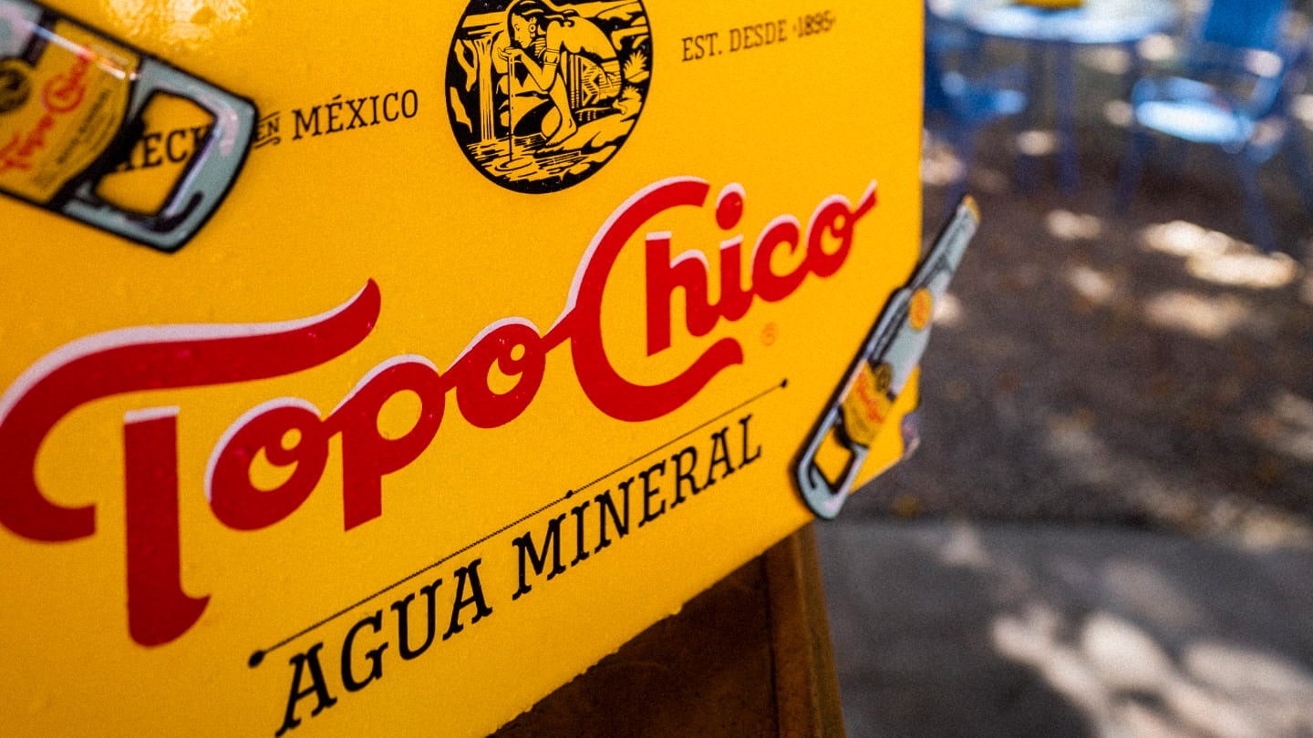 Hombre sentado en Dodo Café junto a una botella Topo Chico