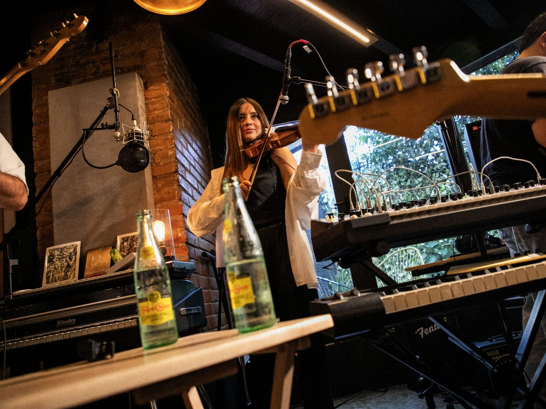 Molinette banda charlando y sosteniendo botellas de Topo Chico