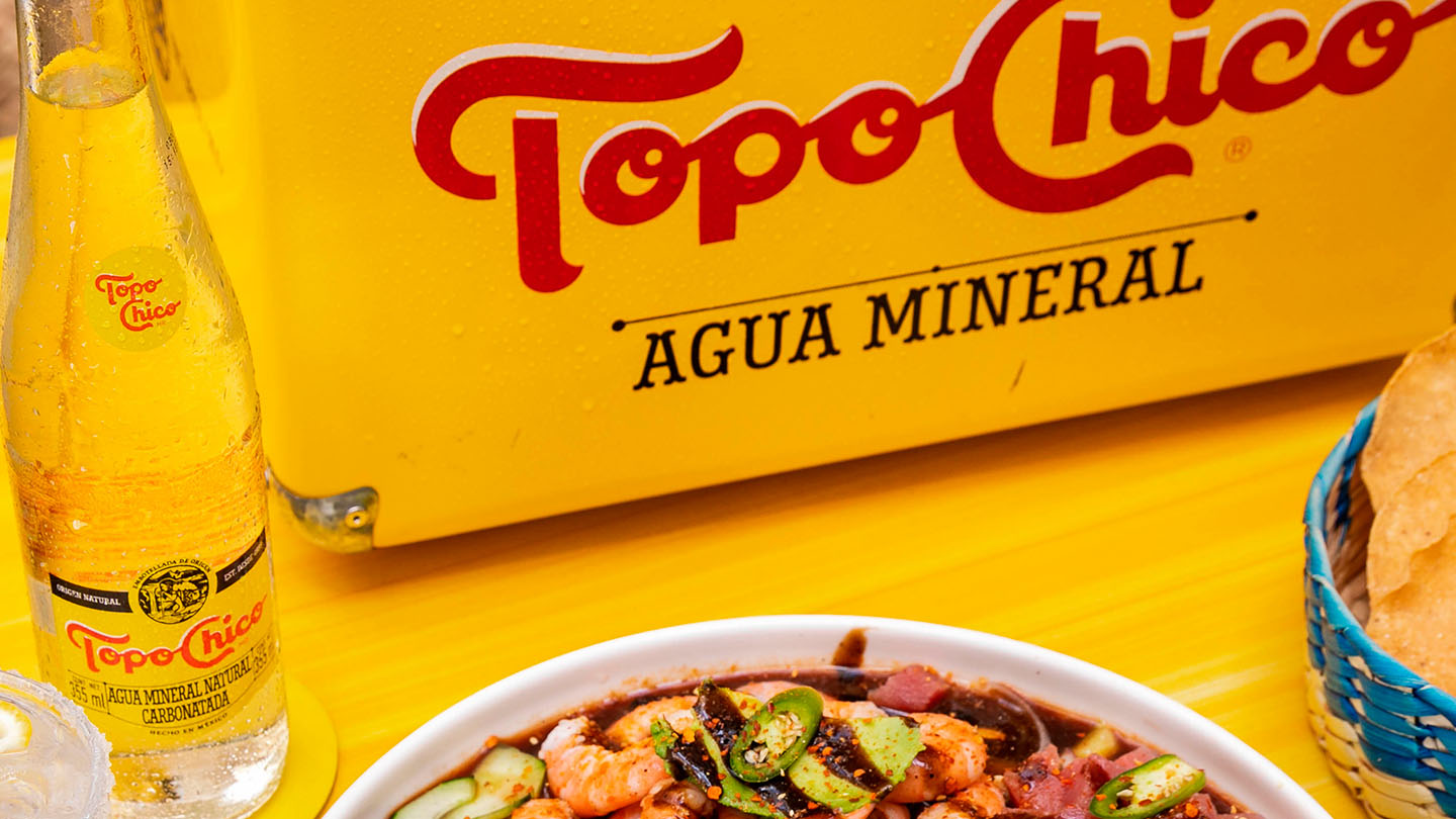 Presentacion de comida Gourmet con Topo Chico agua mineral.