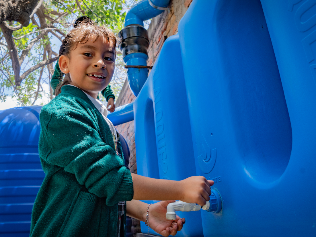 Imagen de una niña abriendo una canilla de agua