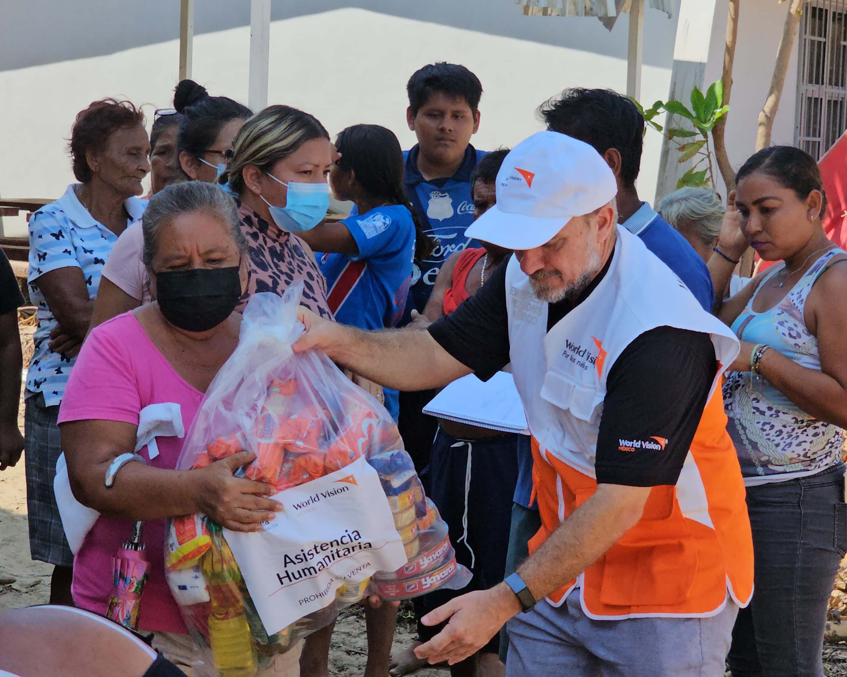 Imagen de una señora recibiendo una bolsa de ayuda humanitaria