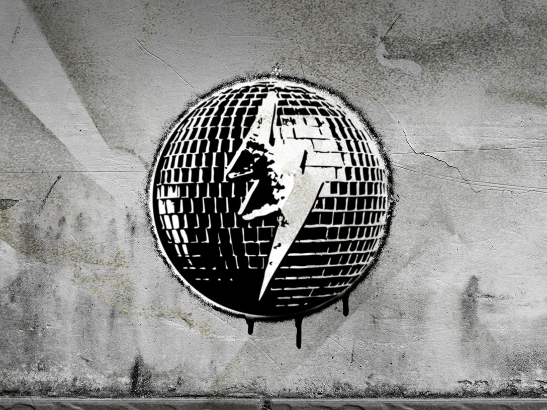 Graffiti en blanco y negro de una bola de discoteca con un rayo blanco en el centro, pintado sobre una pared de concreto texturizado.