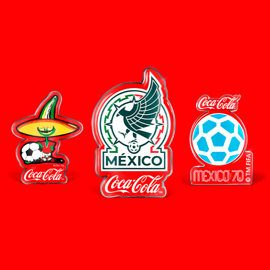Tres pines coleccionables de Coca-Cola con temática de fútbol y la Selección Mexicana sobre un fondo rojo: La mascota con sombrero, el escudo de la Selección Mexicana y el logo del Mundial México 70.