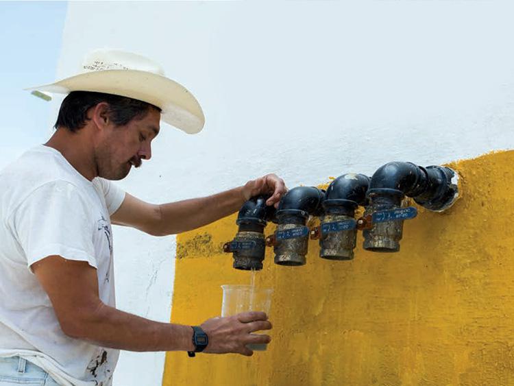 Hombre llena un recipiente con agua