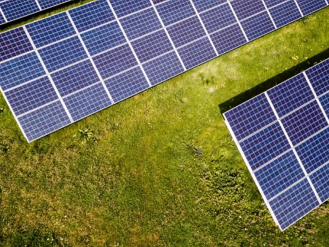 Top view of solar cell panels on a green field