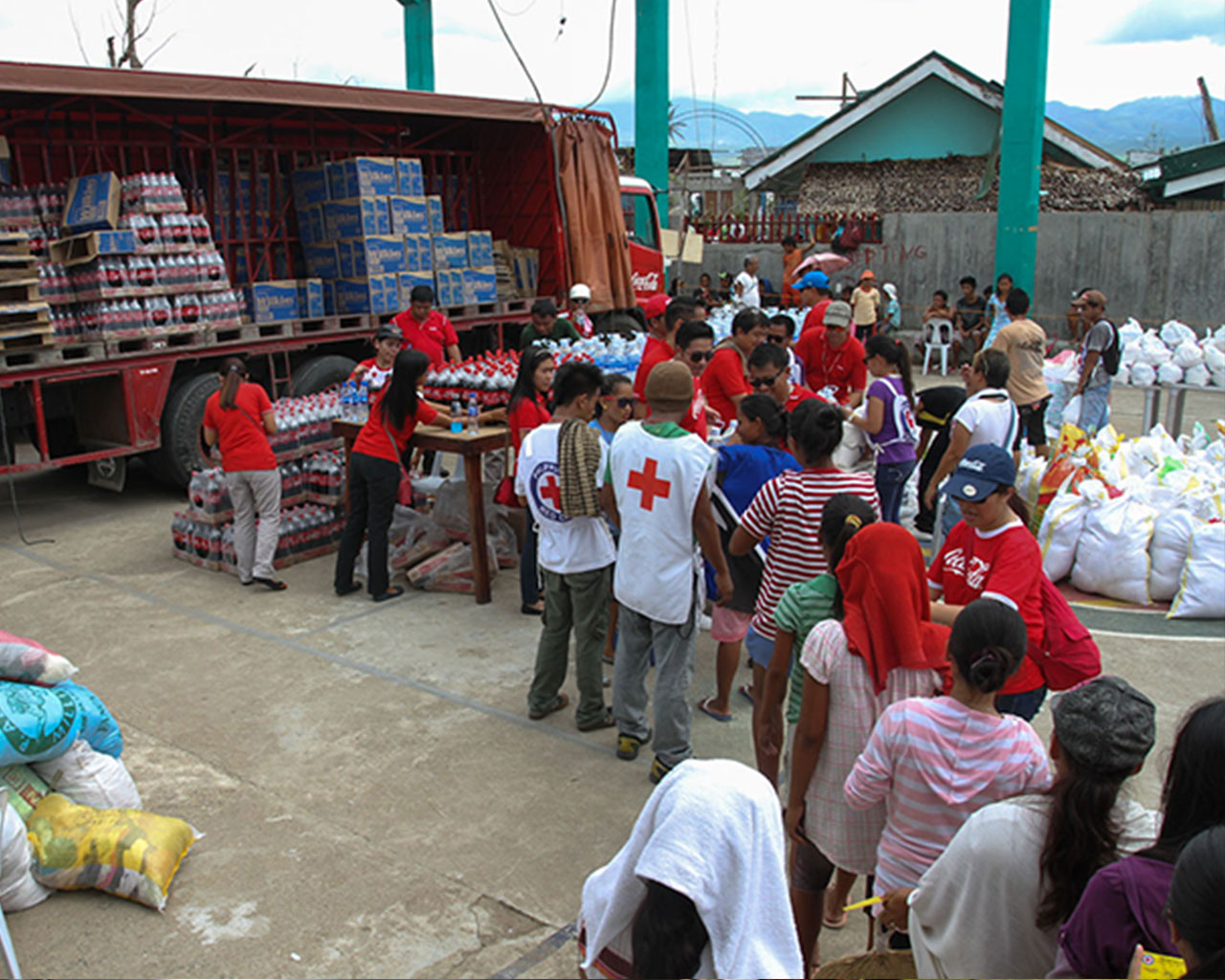 A group of people in front of a truck loaded with products