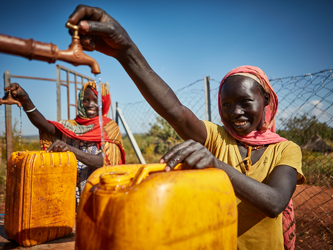 Women filling water containers in Bambasi district, part of the The Replenish Africa Initiative (RAIN) initiative